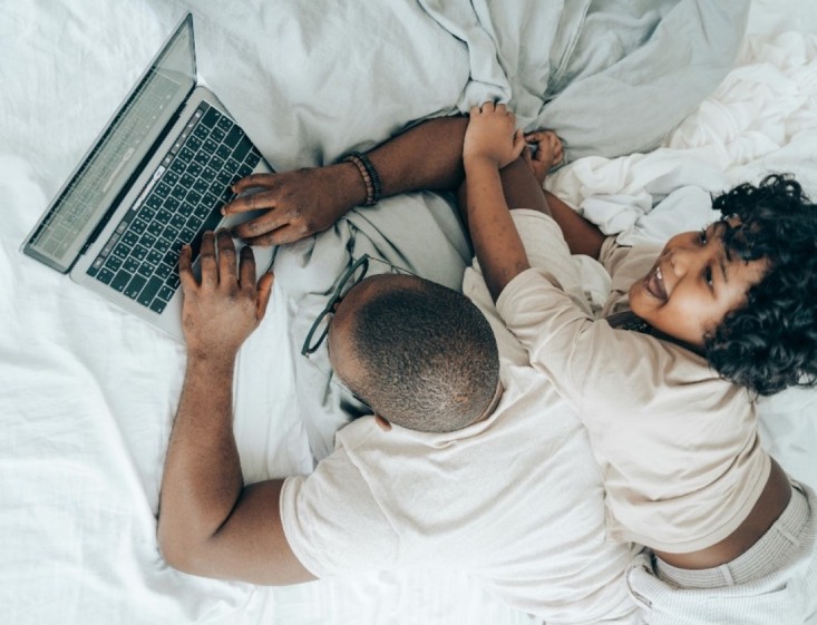 un homme travaille sur son ordinateur portable. son enfant est avec lui.