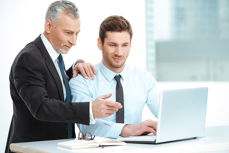 deux hommes regardant un ordinateur portable