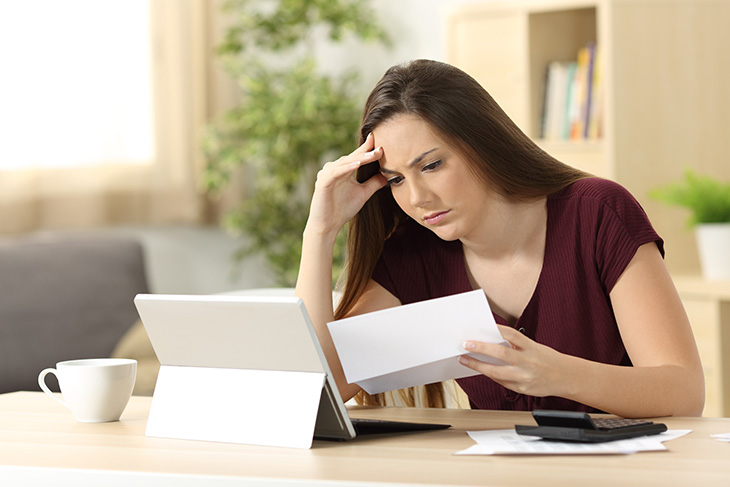 Femme sur sa tablette avec une lettre à la main