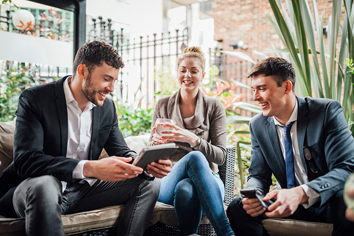 trois collègues sourient et discutent